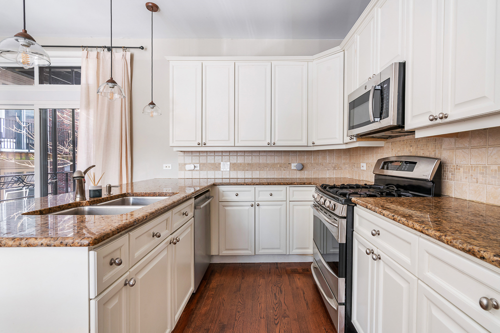 1002 West Altgeld Street, Unit 1002 Chicago, IL 60614 - Photo 7 of 39 a kitchen with stainless steel appliances granite countertop a sink and a stove