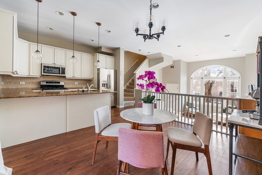 1002 West Altgeld Street, Unit 1002 Chicago, IL 60614 - Photo 10 of 39 a kitchen with stainless steel appliances granite countertop a kitchen island a stove a table and chairs