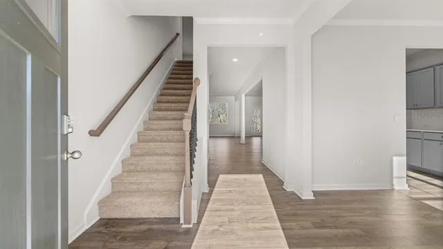 a view of a hallway with wooden floor and staircase