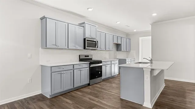 a kitchen with stainless steel appliances granite countertop a stove top oven a sink and a microwave