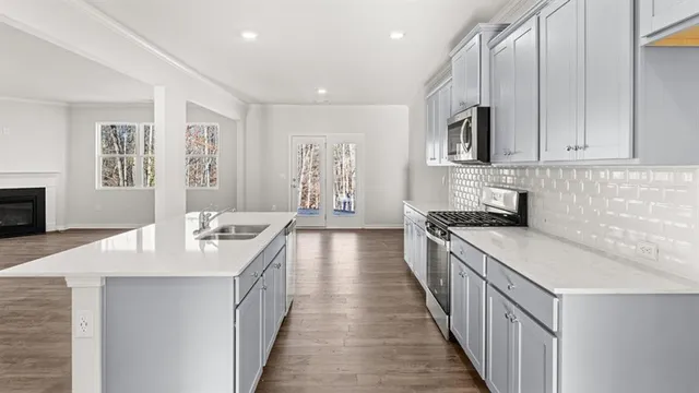 a kitchen with stainless steel appliances granite countertop a sink stove and cabinets