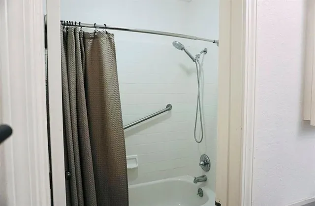 a bathroom with a shower and a glass door