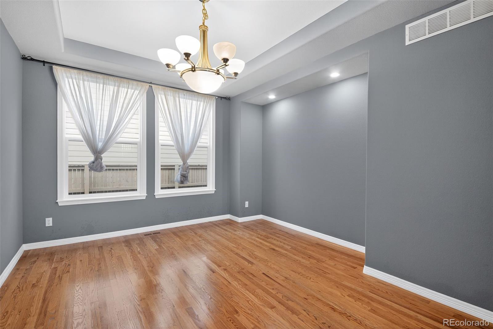 11036 Glengate Circle Highlands Ranch, CO 80130 - Photo 13 of 31 a view of an empty room with wooden floor and a window