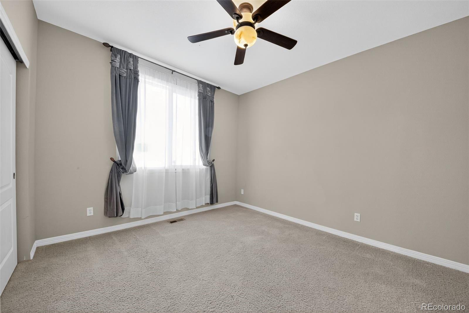 11036 Glengate Circle Highlands Ranch, CO 80130 - Photo 15 of 31 an empty room with windows and fan