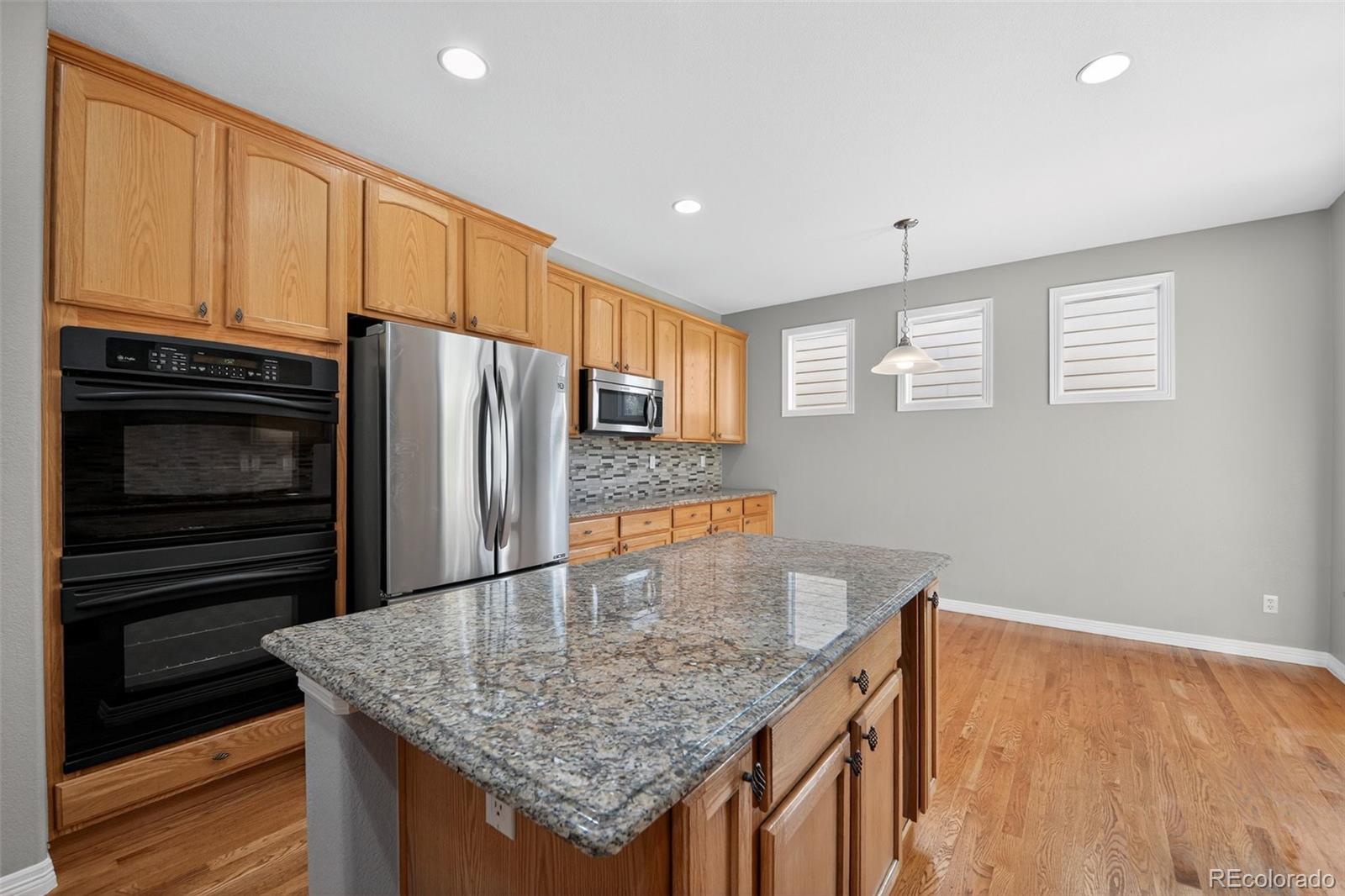 11036 Glengate Circle Highlands Ranch, CO 80130 - Photo 20 of 31 a kitchen with stainless steel appliances granite countertop a refrigerator and microwave
