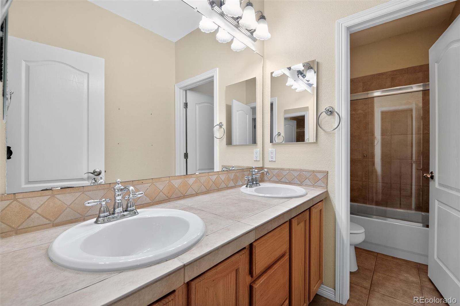 11036 Glengate Circle Highlands Ranch, CO 80130 - Photo 24 of 31 a bathroom with a double vanity sink and a mirror