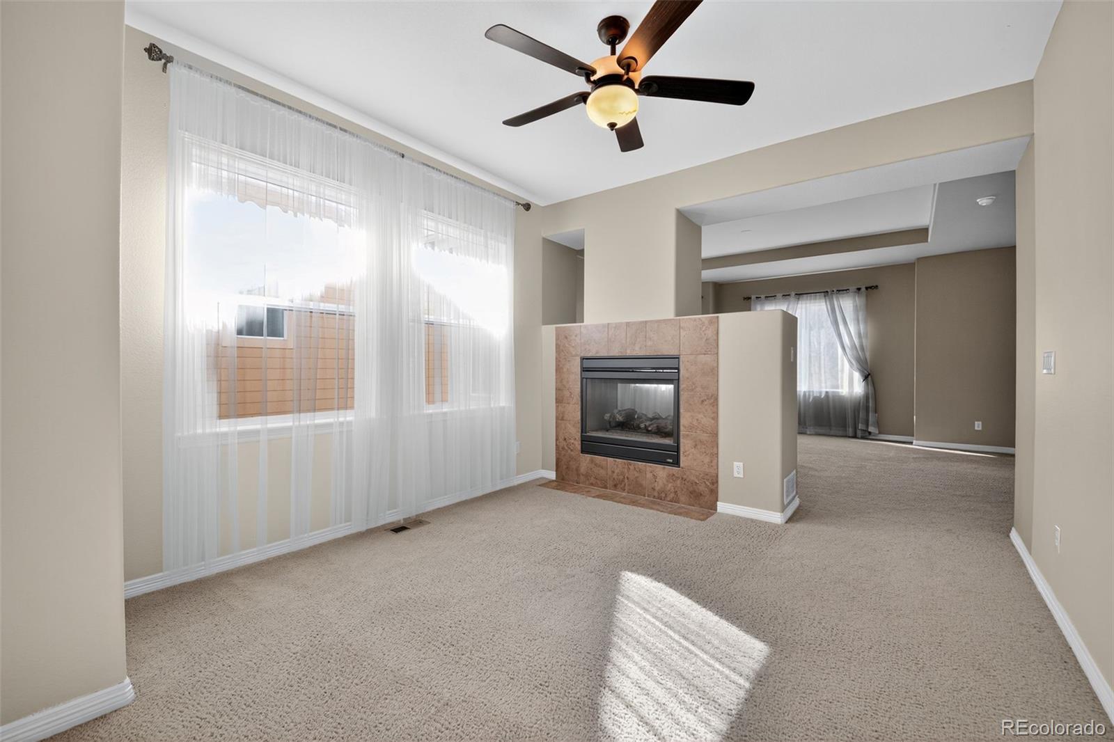 11036 Glengate Circle Highlands Ranch, CO 80130 - Photo 6 of 31 a view of an empty room with a fireplace and a window