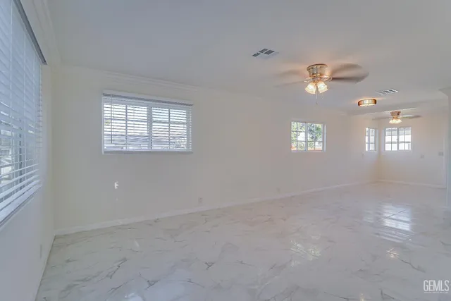 en empty room with windows and ceiling fan view