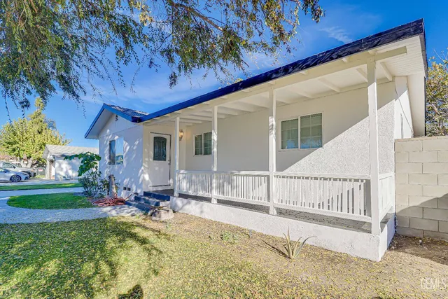 a view of a house with backyard and sitting area