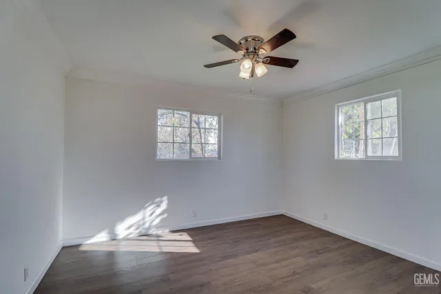 a view of empty room with wooden floor and window