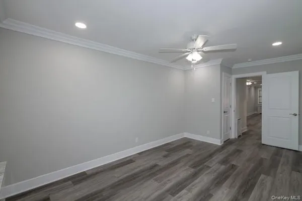 a view of a room with wooden floor and a ceiling fan