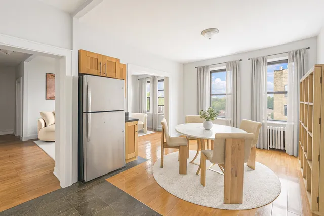 a dining room with wooden floor a glass table and chairs