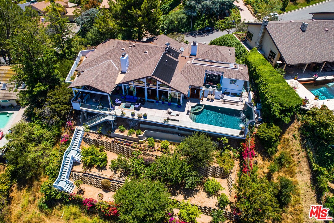 an aerial view of a house with swimming pool and a yard