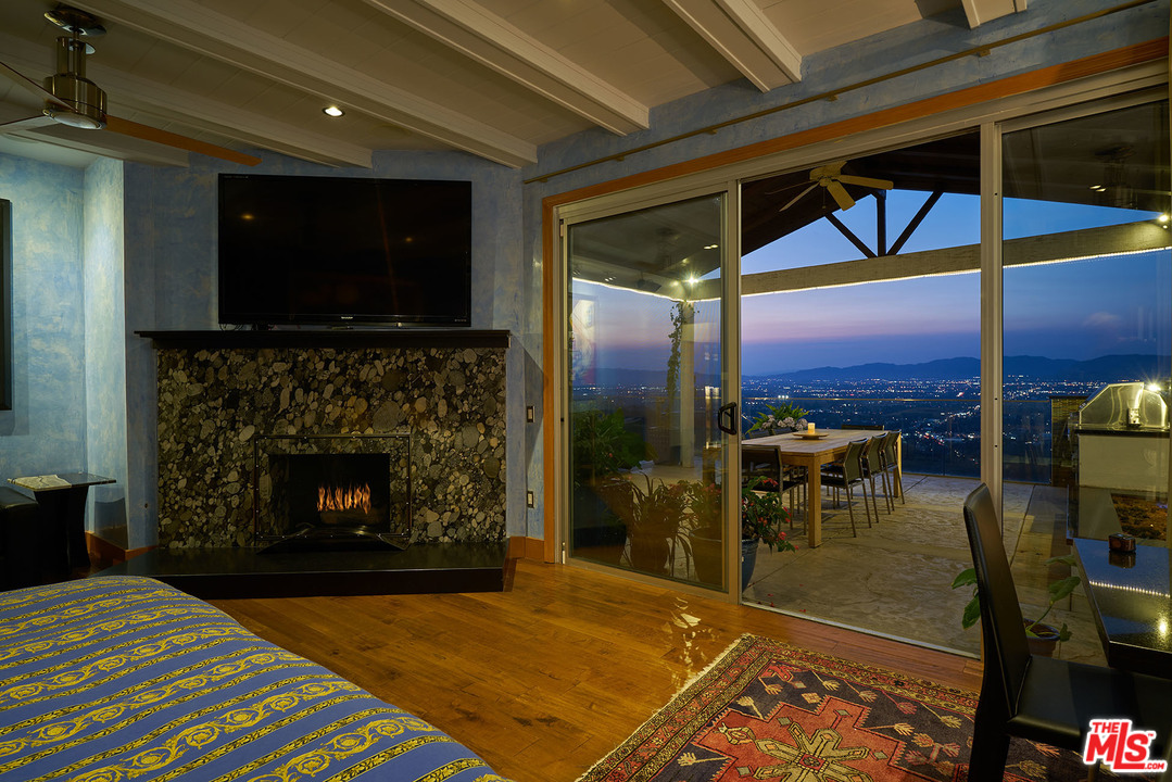 8647 Edwin Drive Los Angeles, CA 90046 - Photo 12 of 32 a living room with a fireplace a flat screen tv and outdoor view
