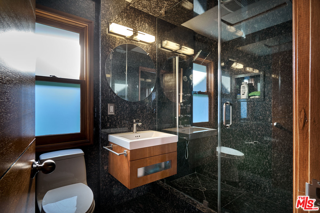 8647 Edwin Drive Los Angeles, CA 90046 - Photo 21 of 32 a bathroom with a mirror a sink and glass door