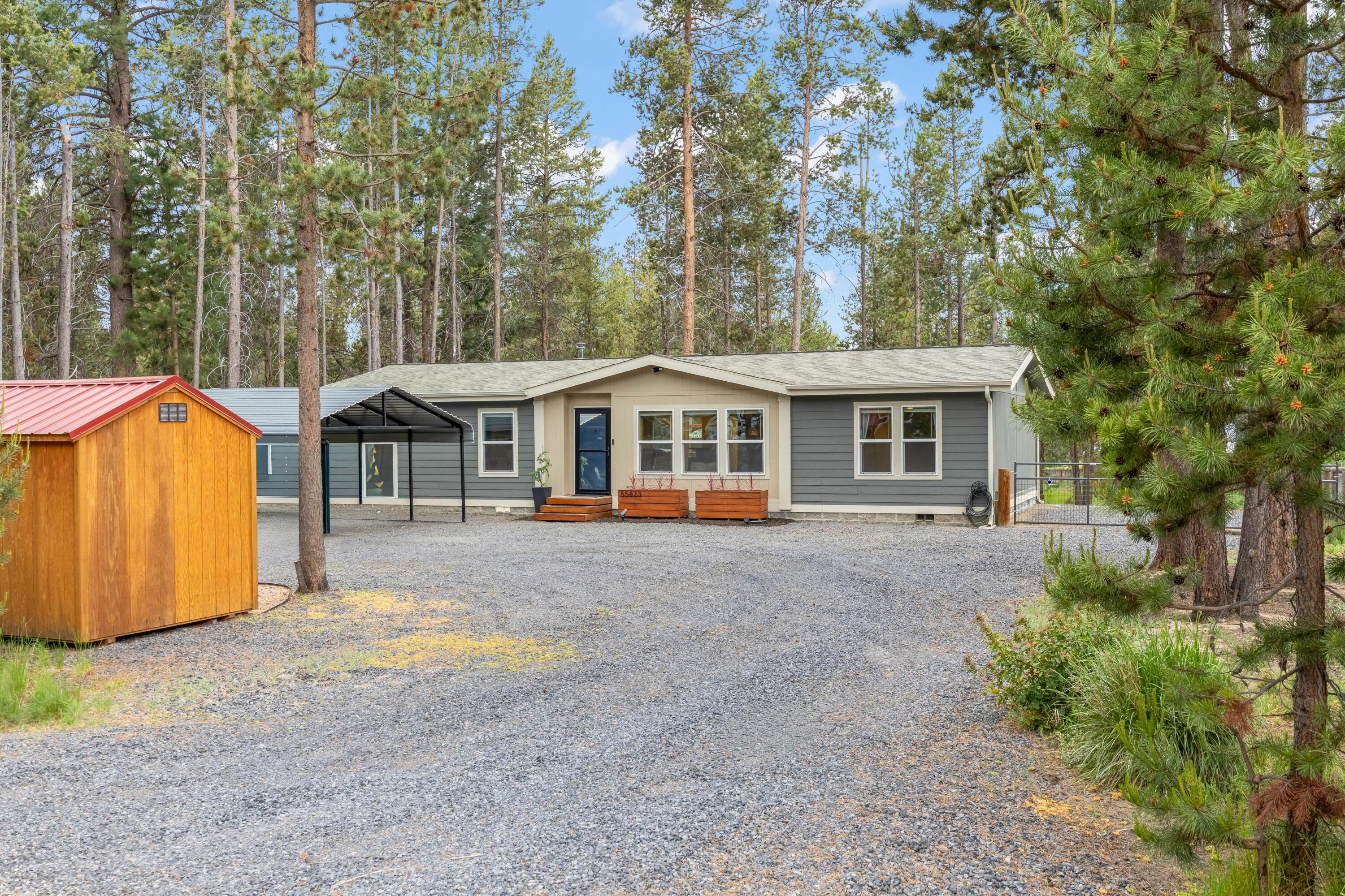 55823 Snow Goose Road Bend, OR 97707 - Photo 1 of 36 a front view of a house with large trees