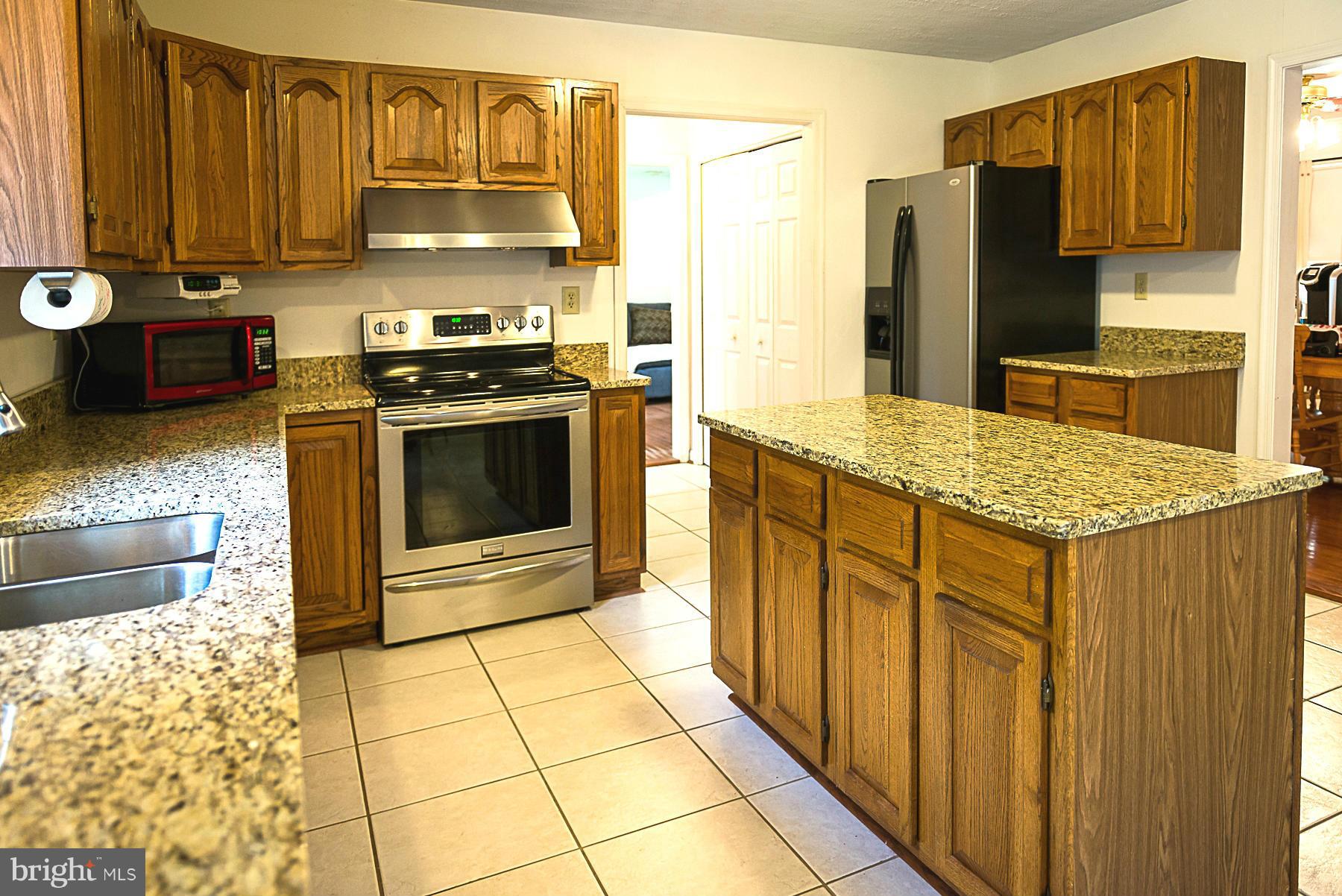 7105 Henson Landing Road Welcome, MD 20693 - Photo 7 of 30 Kitchen granite tops, island, and ceramic tile