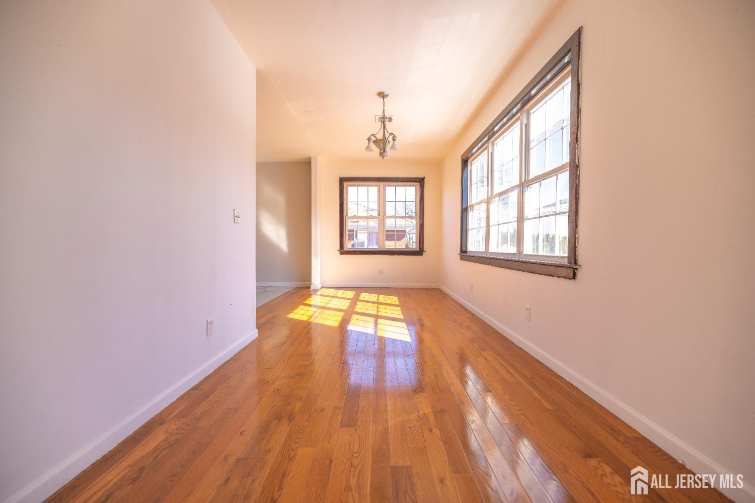 60 Sampson Street Garfield, NJ 07026 - Photo 3 of 9 a view of empty room with wooden floor and fan