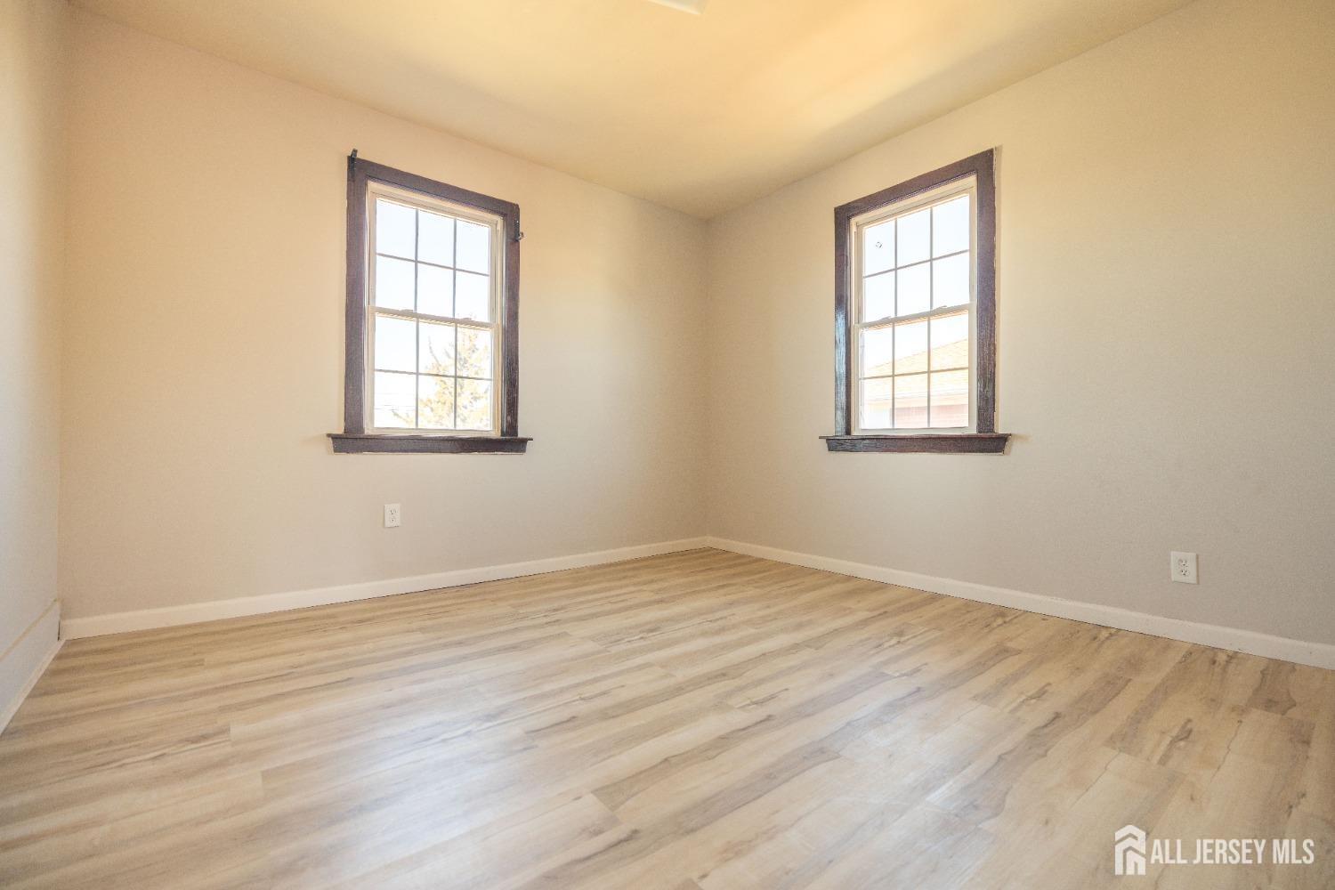 60 Sampson Street Garfield, NJ 07026 - Photo 7 of 9 an empty room with wooden floor and windows