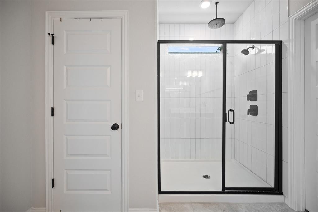 265 Fawn Riv Run Kyle, TX 78640 - Photo 17 of 39 Clean lines and vertical wall tile define this modern walk-in shower configuration.