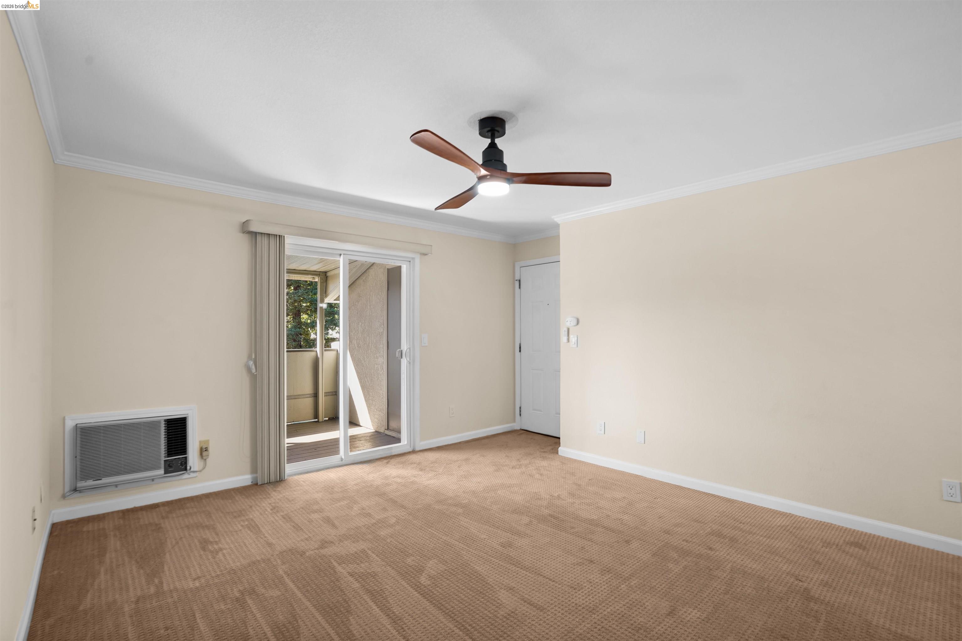 1505 Kirker Pass Road, Unit 214 Concord, CA 94521 - Photo 24 of 55 Carpeted interior space featuring a ceiling fan with integrated lighting, crown molding, and a sliding glass door leading to an exterior balcony