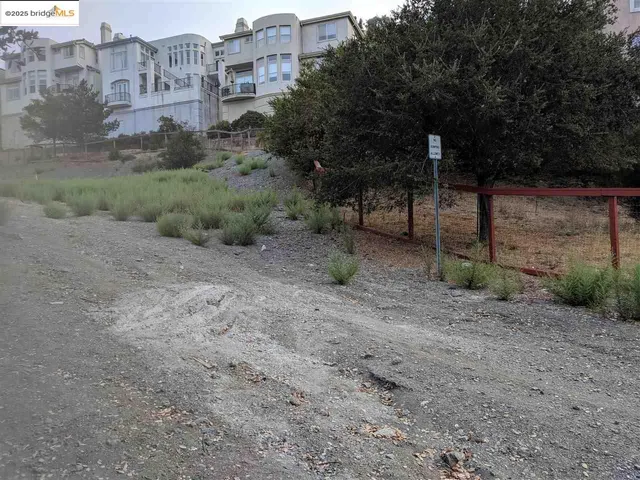 a view of a dry yard with wooden fence