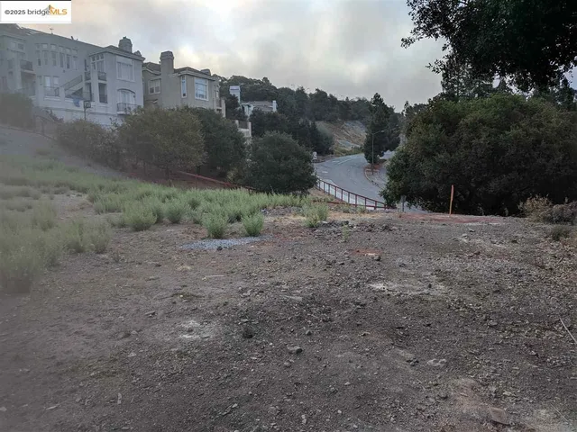 a view of a dirt road with tall buildings
