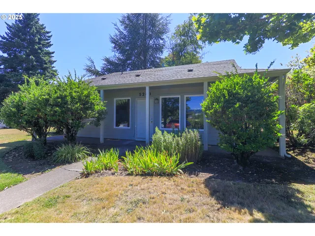 a front view of a house with a yard and a garden