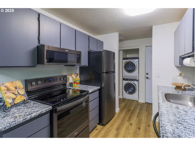 a kitchen with a refrigerator and a stove top oven