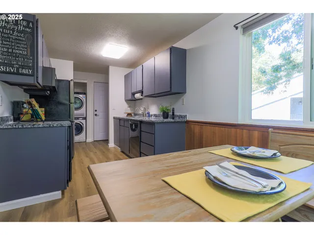 a kitchen with stainless steel appliances granite countertop a sink dishwasher and cabinets with wooden floor