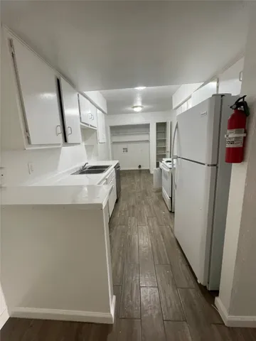 a kitchen with a refrigerator a stove and a sink