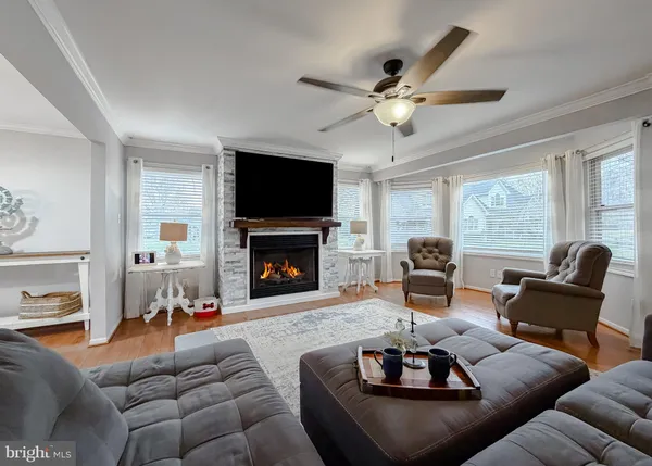 a large kitchen with stainless steel appliances a stove a sink dishwasher a refrigerator and white cabinets with wooden floor