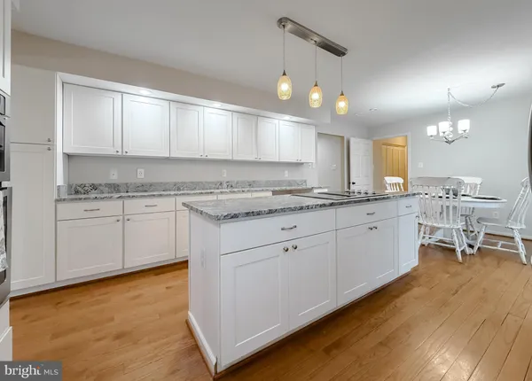 a view of a dining room with furniture a chandelier and wooden floor
