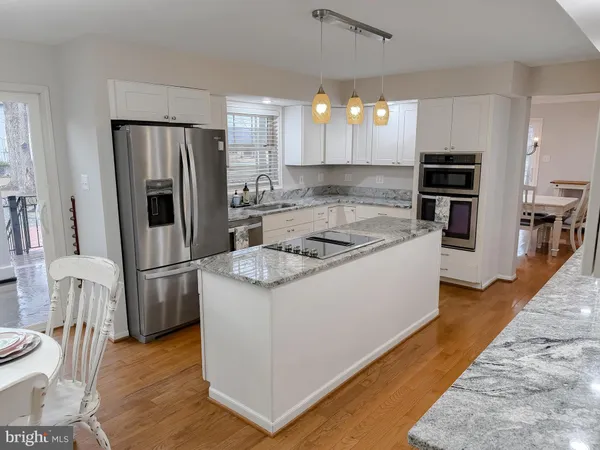 a dining room with wooden floor a chandelier a wooden table and chairs