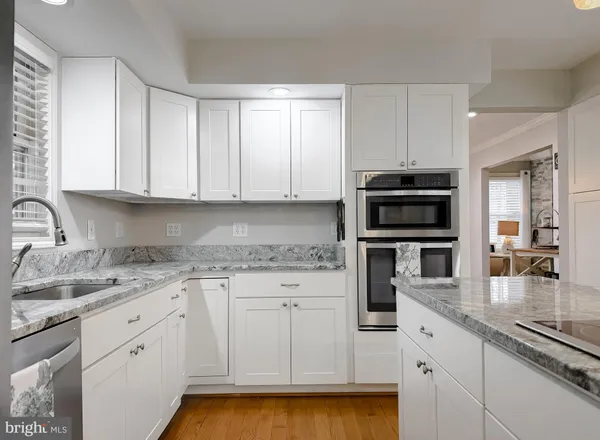 a dining room with wooden floor a chandelier a wooden table and chairs