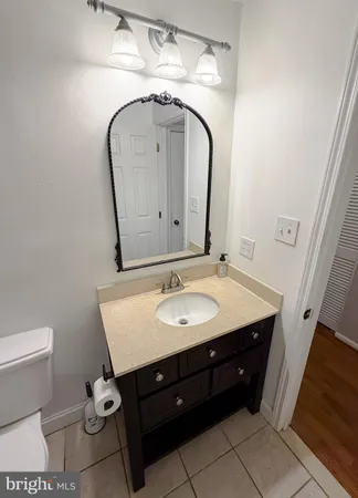 a spacious bathroom with a granite countertop sink a toilet and a mirror