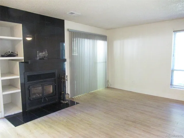 a view of an empty room with window and fire place