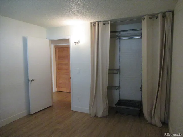 an empty room with wooden floor and a sink