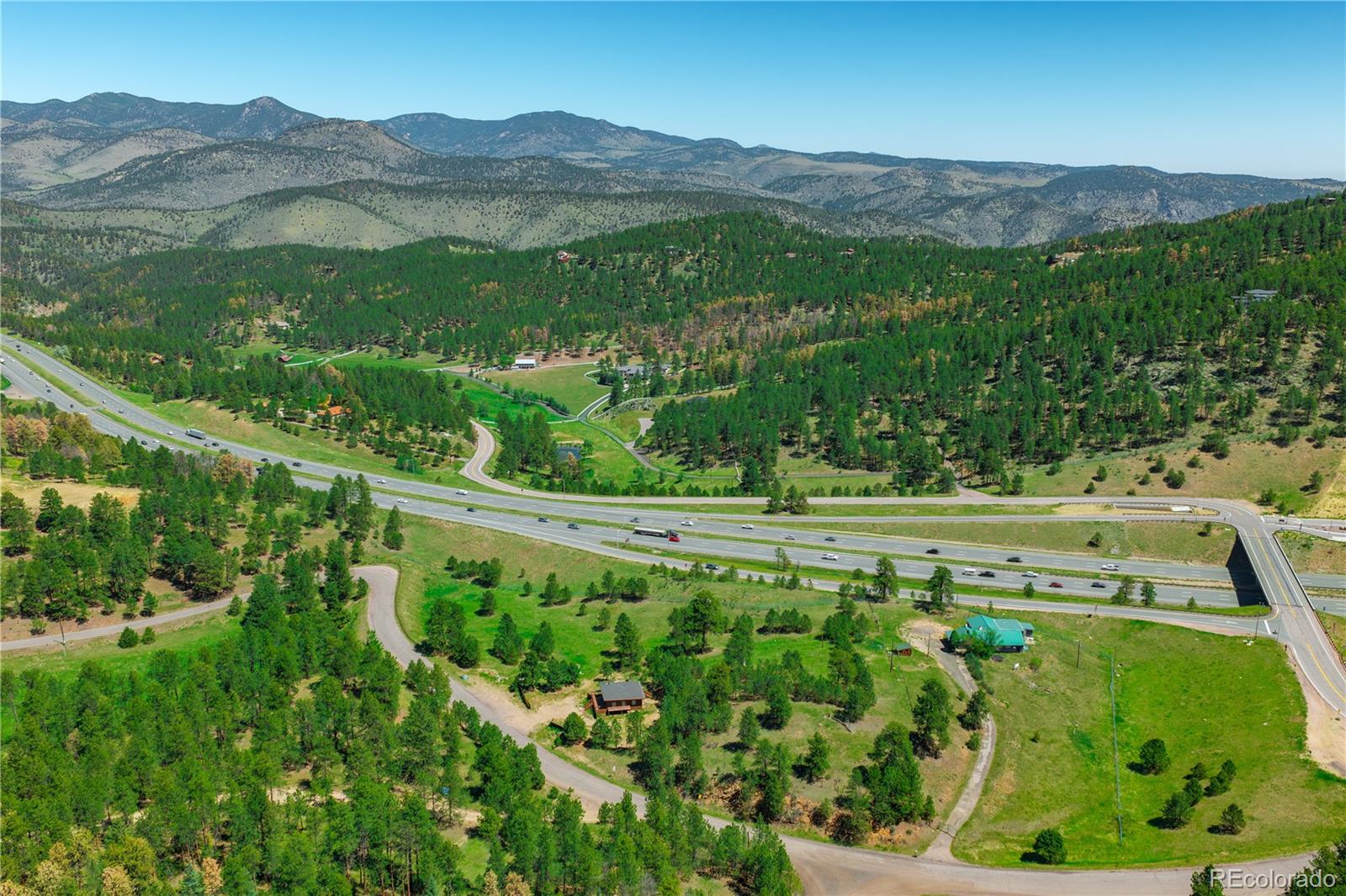 29793 Ruby Ranch Road Evergreen, CO 80439 - Photo 7 of 28 a view of a lush green field with a mountain in the background