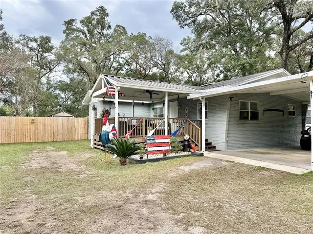 a view of a small house with wooden fence