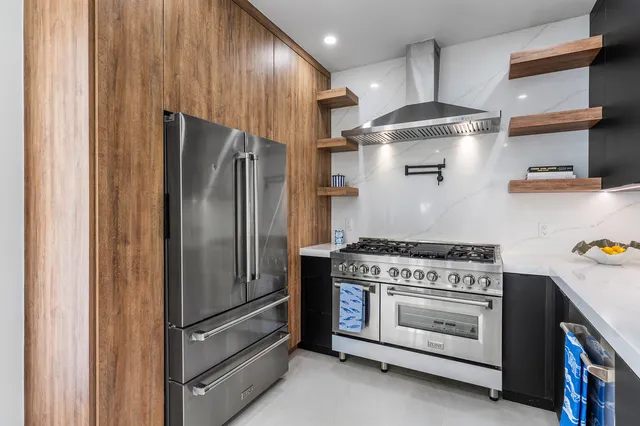 a kitchen with stainless steel appliances granite countertop a stove and a refrigerator