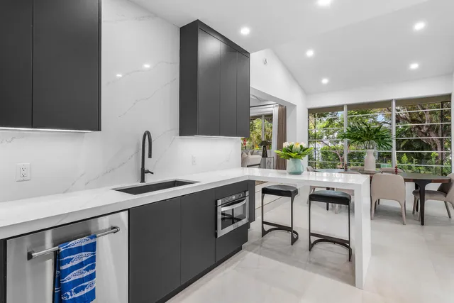 a kitchen with stainless steel appliances granite countertop sink stove and island