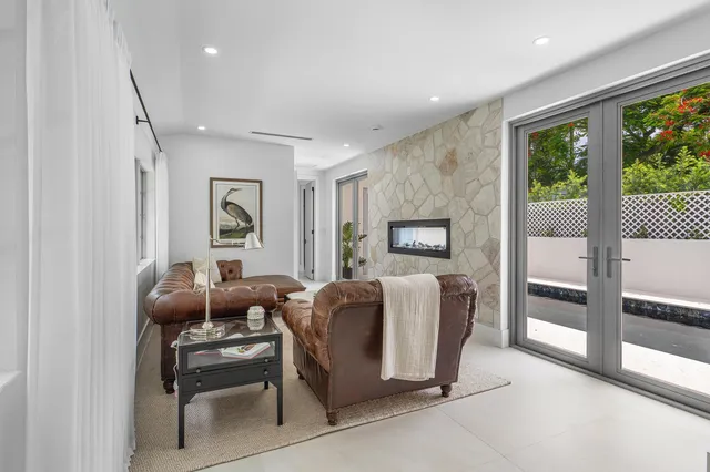 a living room with furniture a flat screen tv and a window