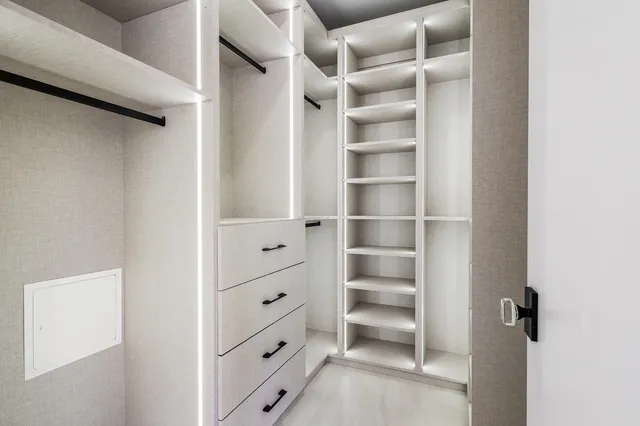 a view of walk in closet with empty racks