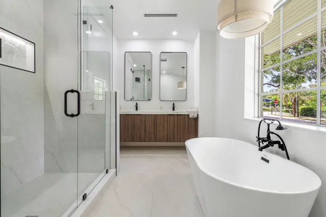 a bathroom with a tub a sink and mirror