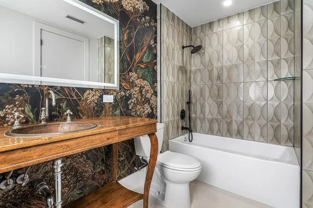 a bathroom with a sink a toilet a mirror and bathtub