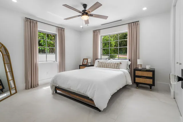 a large bed sitting in a bedroom next to a window