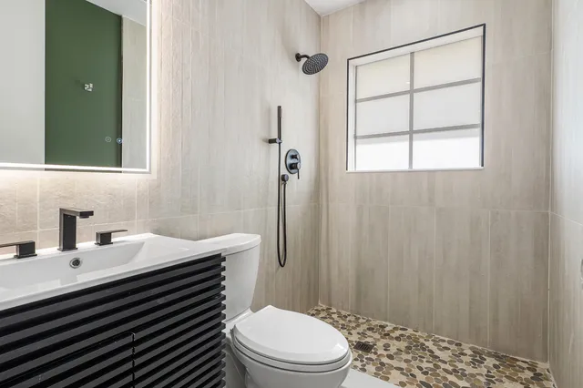 a bathroom with a sink a toilet and shower