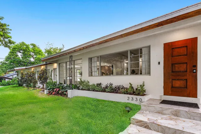 a front view of a house with a garden and yard