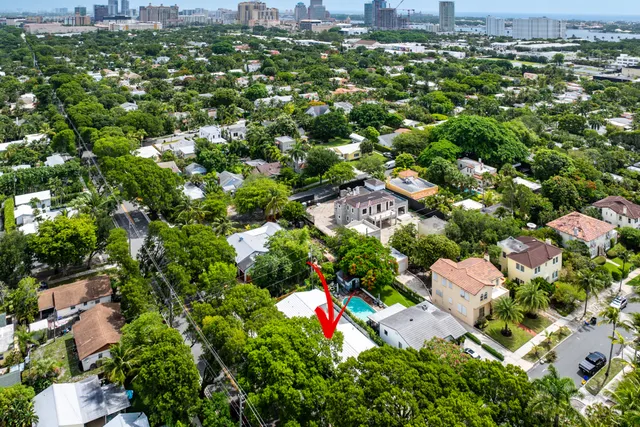 an aerial view of residential houses with outdoor space and trees